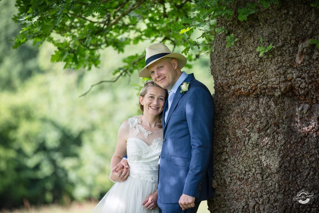 Bride and Groom leading against a tree | Gloucestershire Wedding Photographer