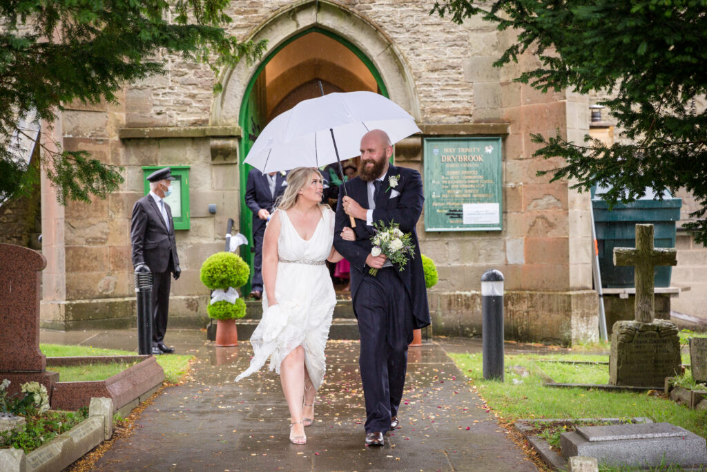 Bride and groom leaving church in the rain, Forest of Dean